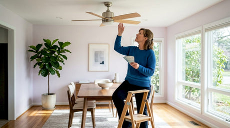 Woman inspecting ceiling fan with wood finish